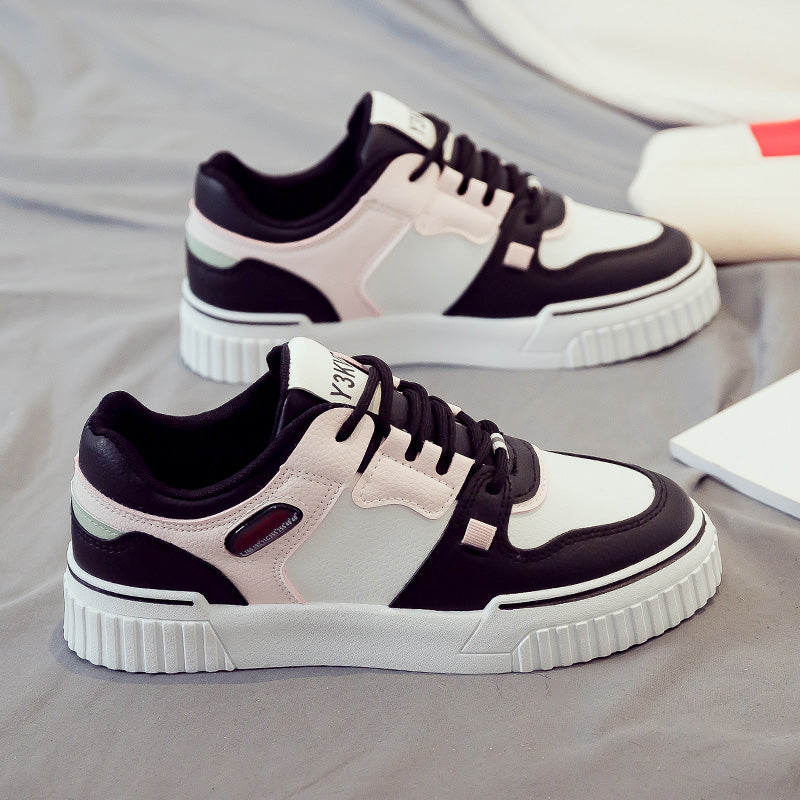 Side view of black and pink sneakers showcasing a sporty and casual design.