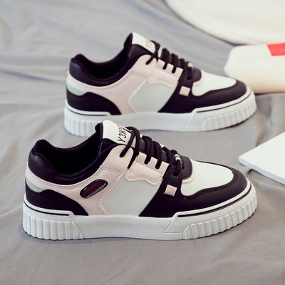 Side view of black and pink sneakers showcasing a sporty and casual design.