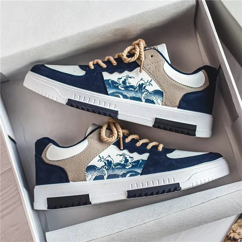 A pair of blue and white men's sneakers with wave patterns displayed in a box.