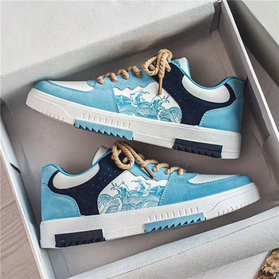 A pair of men's sneakers in blue and white tones with wave patterns, neatly displayed in a box.