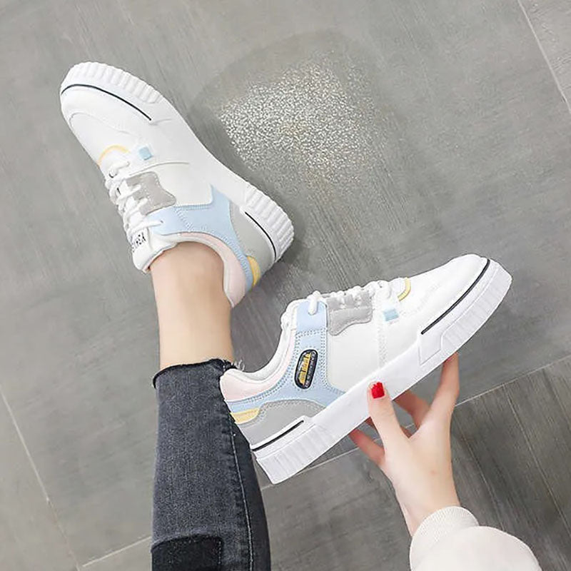 Close-up of pastel sneakers worn with jeans, displaying a relaxed, everyday look.